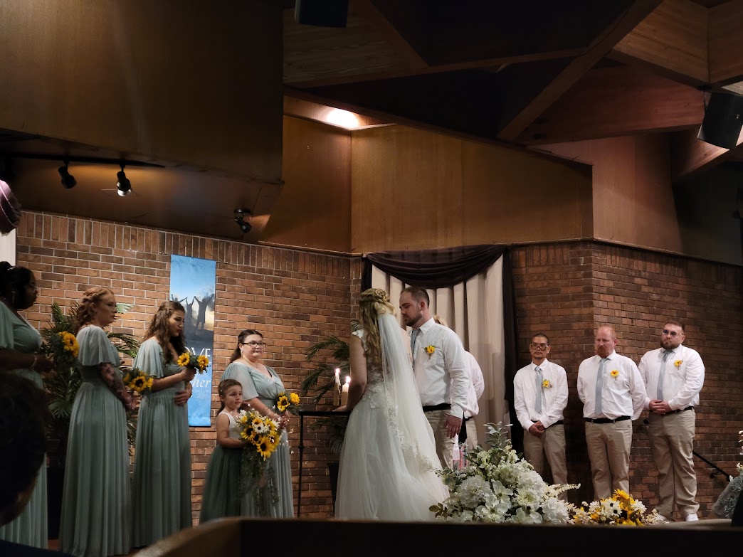 Bride, Groom, and Bridal Party on the platform. Bride and Groom lighting the Unity Candle.